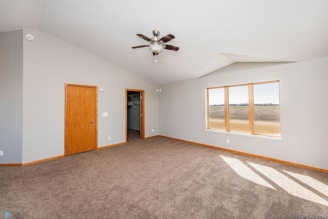 2717 88th Ave S, Fargo, ND 58104 - carpeted spare room featuring vaulted ceiling, a ceiling fan, baseboards, a textured ceiling, and a smoke detector