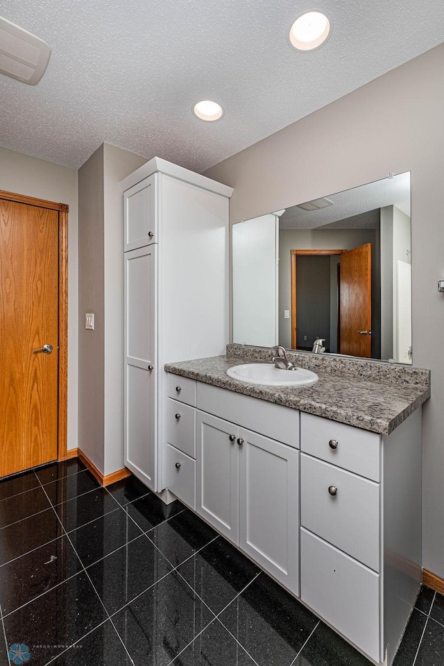 2717 88th Ave S, Fargo, ND 58104 - bathroom with baseboards, vanity, recessed lighting, granite tiled floors, and a textured ceiling