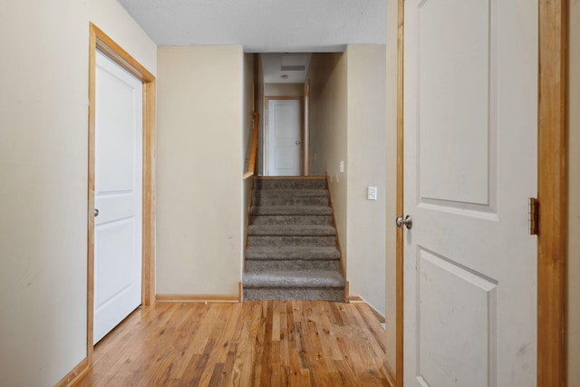 1599 Rice St, Saint Paul, MN 55117 - staircase with wood finished floors, baseboards, and a textured ceiling