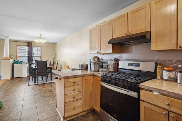 1599 Rice St, Saint Paul, MN 55117 - kitchen with gas range, under cabinet range hood, a peninsula, a chandelier, and tile counters