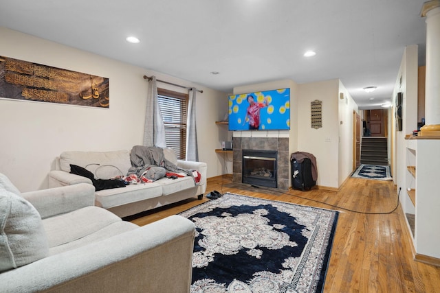 1599 Rice St, Saint Paul, MN 55117 - living area featuring wood finished floors, a tiled fireplace, stairway, recessed lighting, and baseboards