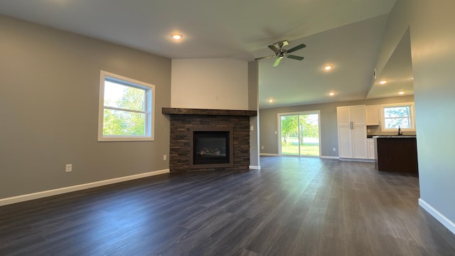13386 Palomino Rd, Bertha Twp, MN 56437 - unfurnished living room featuring baseboards, a stone fireplace, ceiling fan, dark wood-style flooring, and a sink