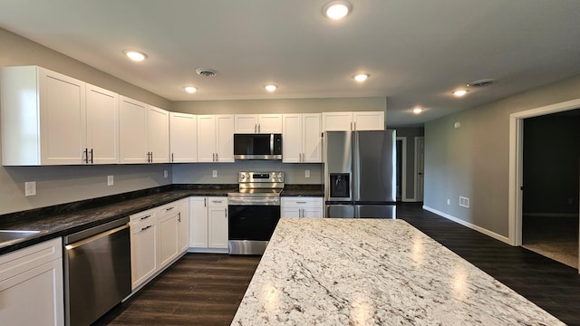 13386 Palomino Rd, Bertha Twp, MN 56437 - kitchen featuring stainless steel appliances, dark wood-style floors, white cabinetry, recessed lighting, and dark stone countertops