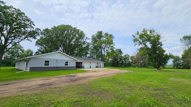 13386 Palomino Rd, Bertha Twp, MN 56437 - view of side of property featuring dirt driveway, a garage, and a yard