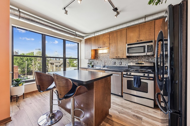 15 Franklin Ave Unit 312, Minneapolis, MN 55404 - kitchen with appliances with stainless steel finishes, dark countertops, a sink, backsplash, and brown cabinetry