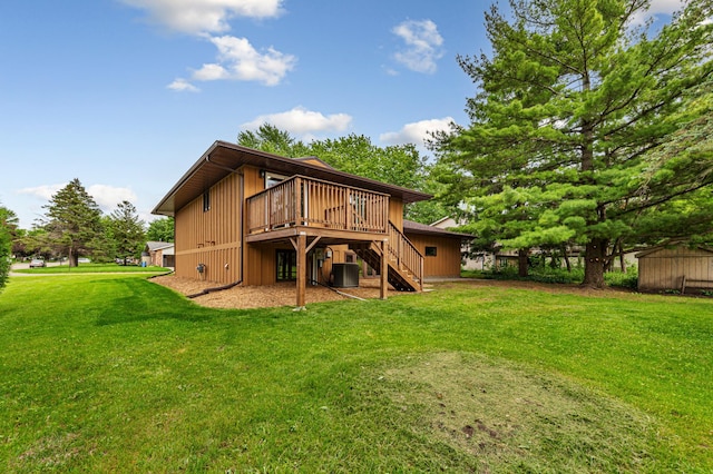 1930 6th Ave NE, Owatonna, MN 55060 - back of property featuring stairs, a wooden deck, a yard, and central AC