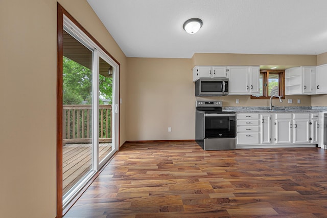 1930 6th Ave NE, Owatonna, MN 55060 - kitchen with stainless steel appliances, wood finished floors, open shelves, and white cabinets