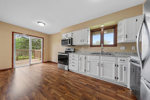 1930 6th Ave NE, Owatonna, MN 55060 - kitchen with appliances with stainless steel finishes, a sink, white cabinets, and dark wood-type flooring