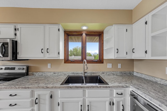 1930 6th Ave NE, Owatonna, MN 55060 - kitchen featuring a sink, open shelves, appliances with stainless steel finishes, white cabinets, and light countertops