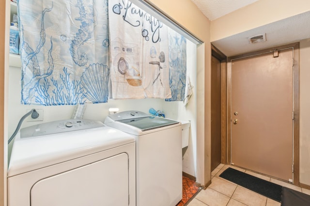 1351 4th St W, Hastings, MN 55033 - laundry area featuring washer and dryer, light tile patterned floors, and a textured ceiling