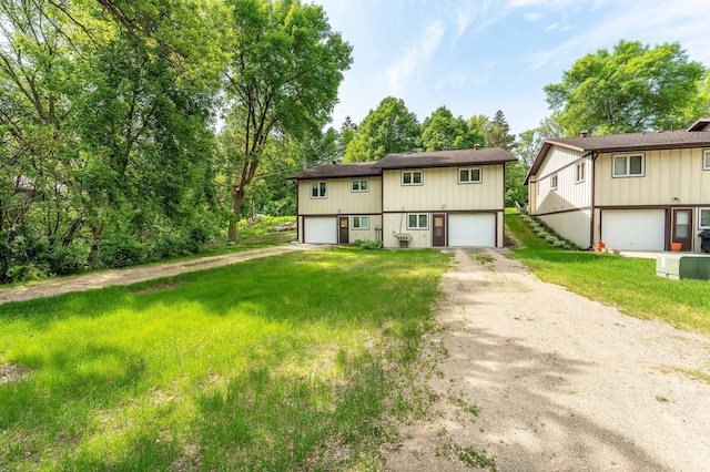 415 2nd Ave SE, Pelican Rapids, MN 56572 - view of front of house with dirt driveway, a front yard, and an attached garage