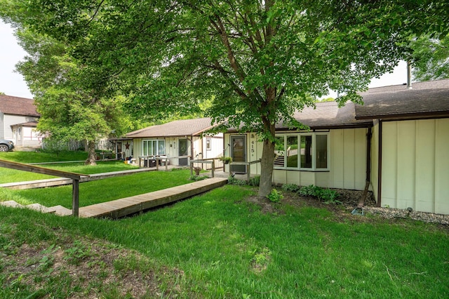 415 2nd Ave SE, Pelican Rapids, MN 56572 - view of front of house with board and batten siding, a front yard, and roof with shingles