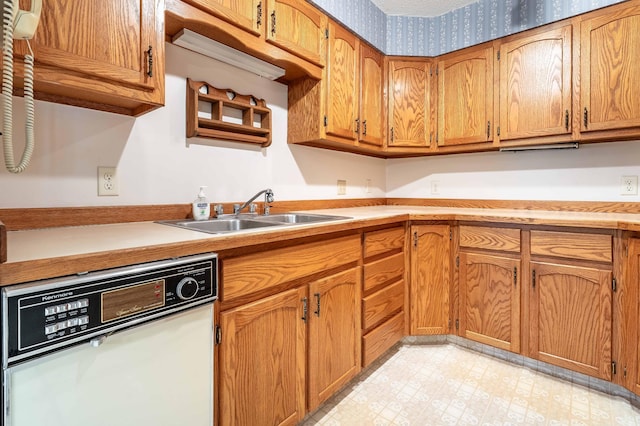 415 2nd Ave SE, Pelican Rapids, MN 56572 - kitchen featuring dishwashing machine, a sink, light countertops, brown cabinetry, and light flooring