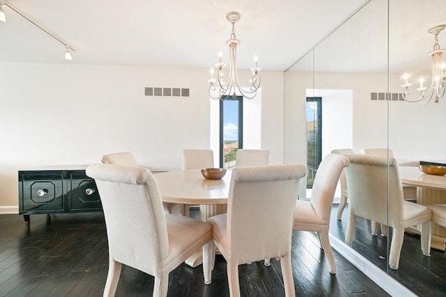 15 1st St Unit A1119, Minneapolis, MN 55401 - dining space featuring a chandelier, dark wood-style floors, track lighting, and baseboards