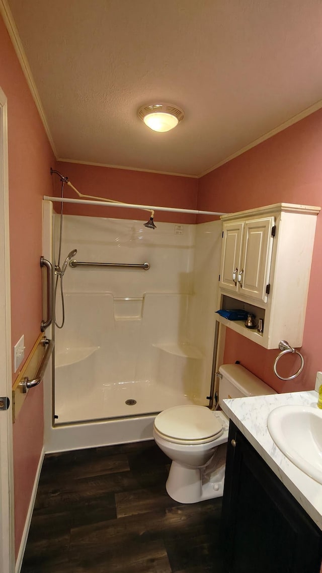 13786 188th Pl, Williams Twp, MN 56350 - bathroom featuring wood finished floors, crown molding, a stall shower, toilet, and vanity