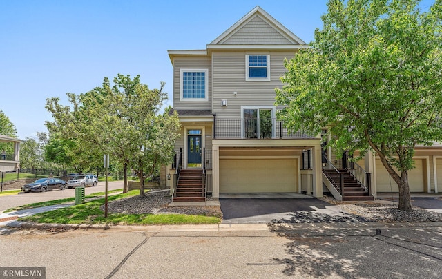 11206 Baltimore St NE Unit A, Blaine, MN 55449 - view of property with stairs, asphalt driveway, an attached garage, and a balcony