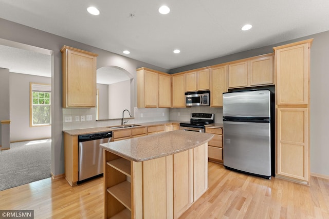 11206 Baltimore St NE Unit A, Blaine, MN 55449 - kitchen featuring appliances with stainless steel finishes, light brown cabinets, a sink, a kitchen island, and light wood-style floors