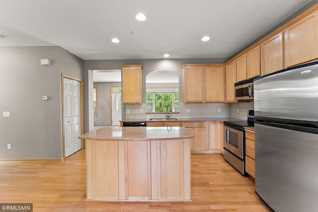 11206 Baltimore St NE Unit A, Blaine, MN 55449 - kitchen featuring stainless steel appliances, light brown cabinets, a sink, light wood-type flooring, and a kitchen island