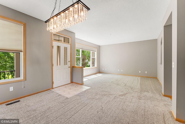 11206 Baltimore St NE Unit A, Blaine, MN 55449 - carpeted entryway featuring a chandelier, baseboards, and a textured ceiling