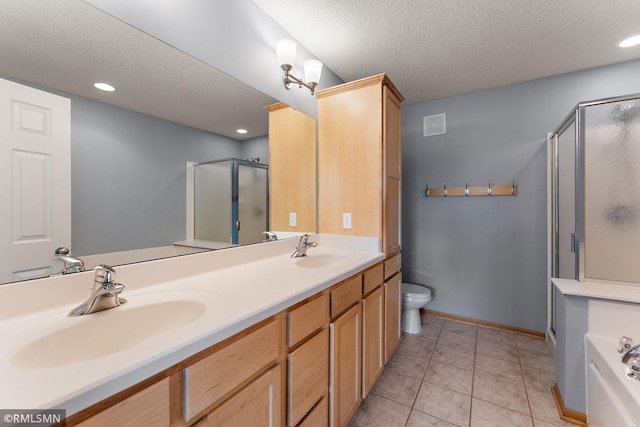 11206 Baltimore St NE Unit A, Blaine, MN 55449 - bathroom featuring a shower stall, a textured ceiling, toilet, double vanity, and tile patterned floors