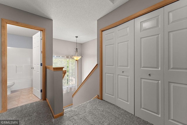 11206 Baltimore St NE Unit A, Blaine, MN 55449 - corridor with an upstairs landing, carpet, baseboards, and a textured ceiling
