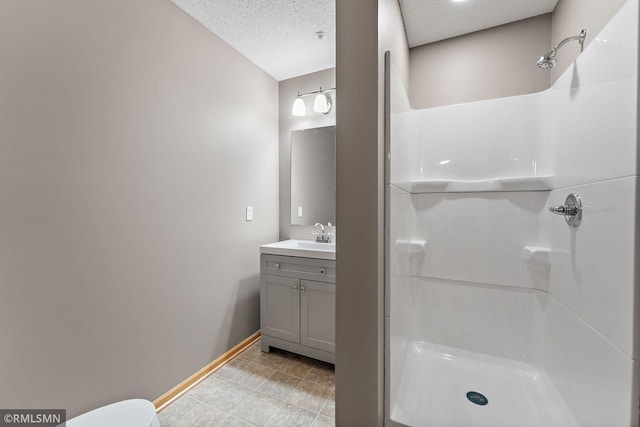 11206 Baltimore St NE Unit A, Blaine, MN 55449 - bathroom featuring vanity, a shower, baseboards, toilet, and tile patterned flooring