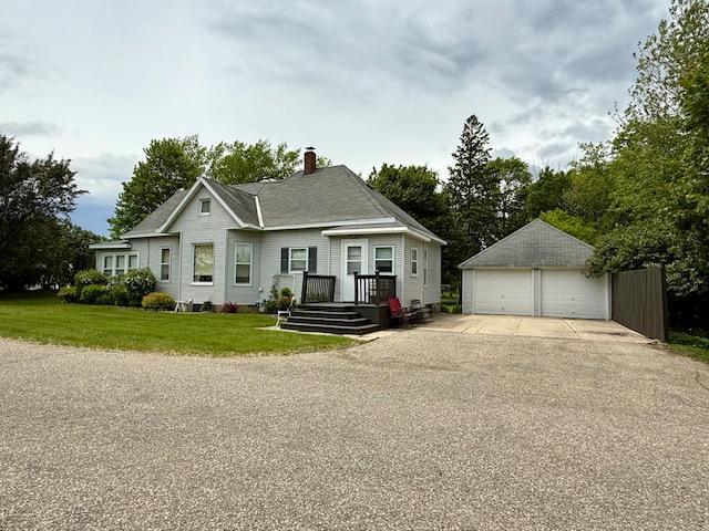 2100 Trott Ave SW, Willmar, MN 56201 - view of front facade featuring a garage, an outbuilding, a front lawn, and a chimney