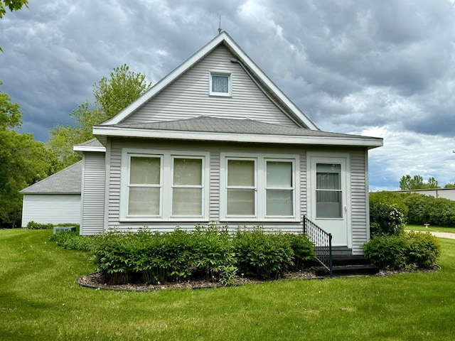 2100 Trott Ave SW, Willmar, MN 56201 - view of property exterior featuring a lawn, roof with shingles, and entry steps