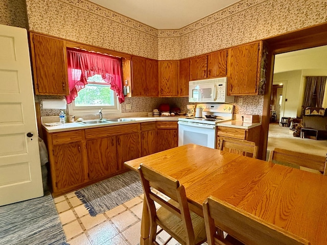 2100 Trott Ave SW, Willmar, MN 56201 - kitchen featuring white appliances, a sink, wallpapered walls, light countertops, and brown cabinetry
