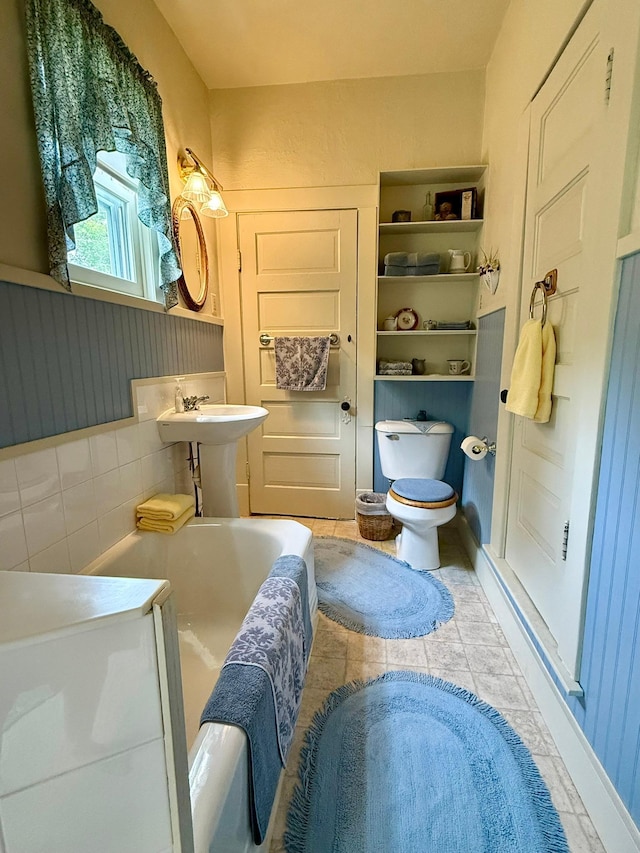 2100 Trott Ave SW, Willmar, MN 56201 - full bathroom with toilet, a tub to relax in, a wainscoted wall, and a sink