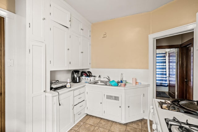 3725 Fremont Ave N, Minneapolis, MN 55412 - kitchen with light countertops, white cabinets, white range with gas cooktop, a sink, and light tile patterned floors