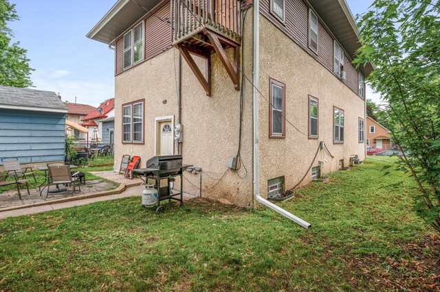 3725 Fremont Ave N, Minneapolis, MN 55412 - back of house with stucco siding, a yard, a patio, and a balcony