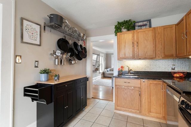 5236 42nd Ave S, Minneapolis, MN 55417 - kitchen with a sink, light tile patterned flooring, backsplash, dark countertops, and baseboards