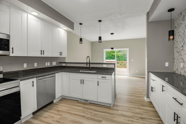 7658 Silver Lake Rd, Mounds View, MN 55112 - kitchen with stainless steel appliances, a sink, a peninsula, and light wood-style floors