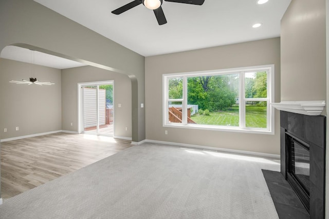 7658 Silver Lake Rd, Mounds View, MN 55112 - unfurnished living room with ceiling fan, a fireplace with flush hearth, baseboards, recessed lighting, and arched walkways