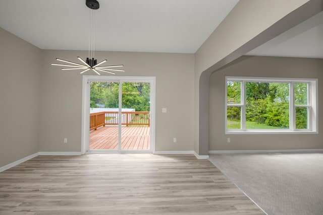 7658 Silver Lake Rd, Mounds View, MN 55112 - unfurnished dining area featuring light wood-type flooring, baseboards, and a chandelier
