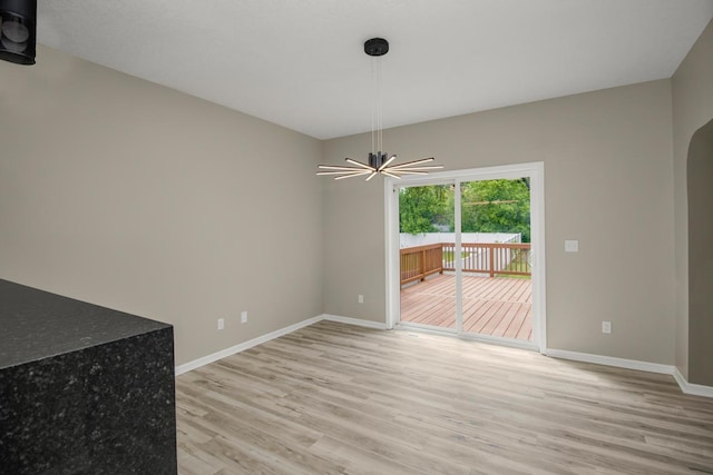 7658 Silver Lake Rd, Mounds View, MN 55112 - unfurnished dining area with light wood-type flooring, baseboards, and arched walkways