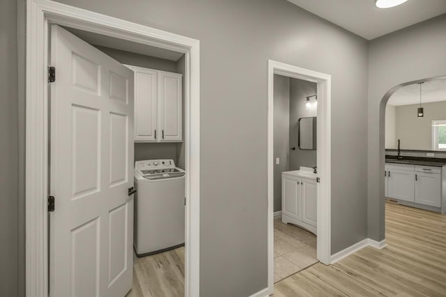 7658 Silver Lake Rd, Mounds View, MN 55112 - laundry room with washer / dryer, cabinet space, light wood finished floors, baseboards, and arched walkways