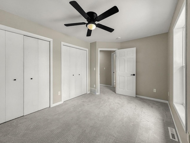 7658 Silver Lake Rd, Mounds View, MN 55112 - unfurnished bedroom with two closets, carpet, baseboards, and ceiling fan