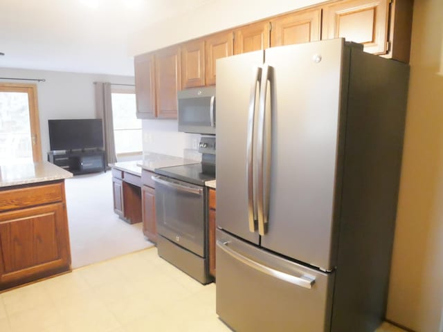 1996 Kingston Ave E, Maplewood, MN 55109 - kitchen featuring appliances with stainless steel finishes, light stone counters, and light floors