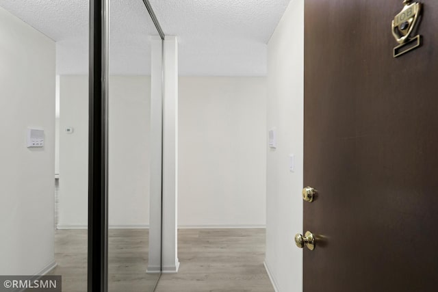 2800 Hillsboro Ave N Unit 108, New Hope, MN 55427 - hall with a textured ceiling, light wood-style flooring, and baseboards