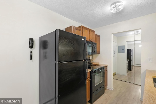 2800 Hillsboro Ave N Unit 108, New Hope, MN 55427 - kitchen featuring black appliances, light countertops, light wood-style flooring, brown cabinetry, and a textured ceiling