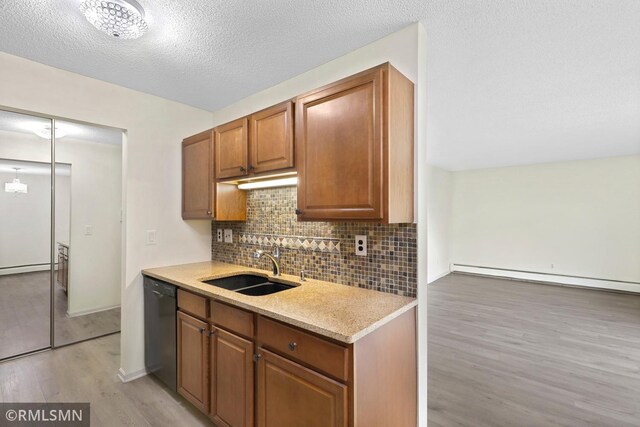 2800 Hillsboro Ave N Unit 108, New Hope, MN 55427 - kitchen with black dishwasher, a sink, light wood-style flooring, tasteful backsplash, and baseboard heating