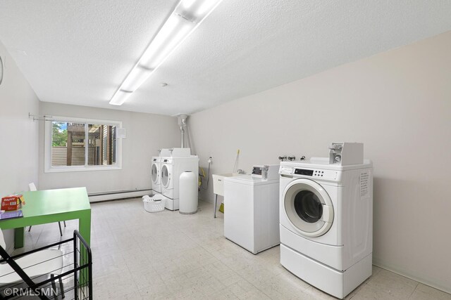 2800 Hillsboro Ave N Unit 108, New Hope, MN 55427 - shared laundry room with separate washer and dryer, a baseboard heating unit, a textured ceiling, and light floors