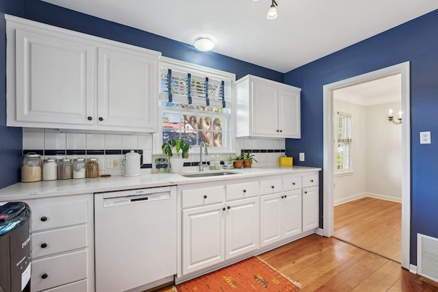 5604 14th Ave S, Minneapolis, MN 55417 - kitchen featuring white dishwasher, a sink, decorative backsplash, light wood-style floors, and white cabinetry