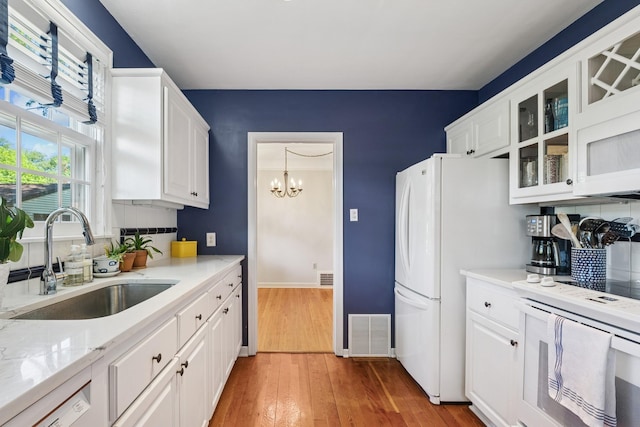 5604 14th Ave S, Minneapolis, MN 55417 - kitchen featuring a sink, white appliances, tasteful backsplash, and white cabinetry