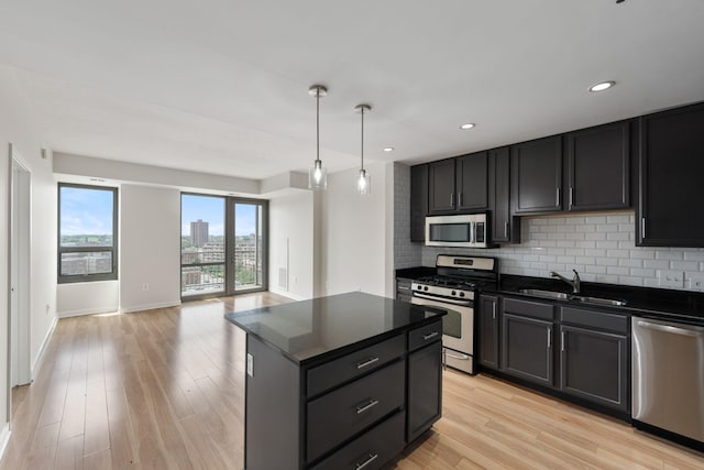 929 Portland Ave Unit 907, Minneapolis, MN 55404 - kitchen with appliances with stainless steel finishes, dark countertops, tasteful backsplash, light wood-type flooring, and a kitchen island