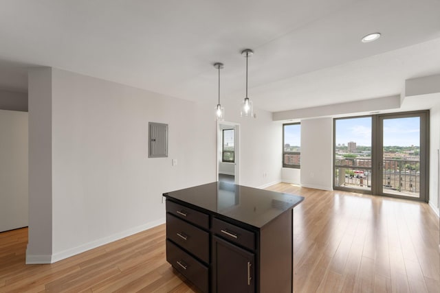 929 Portland Ave Unit 907, Minneapolis, MN 55404 - kitchen with dark countertops, electric panel, light wood-type flooring, a kitchen island, and decorative light fixtures