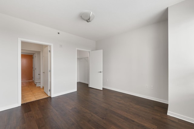 929 Portland Ave Unit 907, Minneapolis, MN 55404 - unfurnished bedroom featuring wood finished floors, a spacious closet, a closet, and connected bathroom