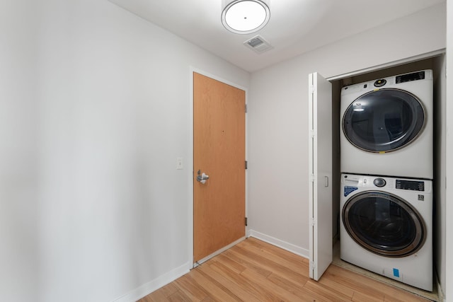 929 Portland Ave Unit 907, Minneapolis, MN 55404 - washroom featuring stacked washing machine and dryer and light wood-type flooring